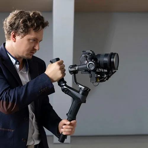 A videographer filming with a camera on a gimbal